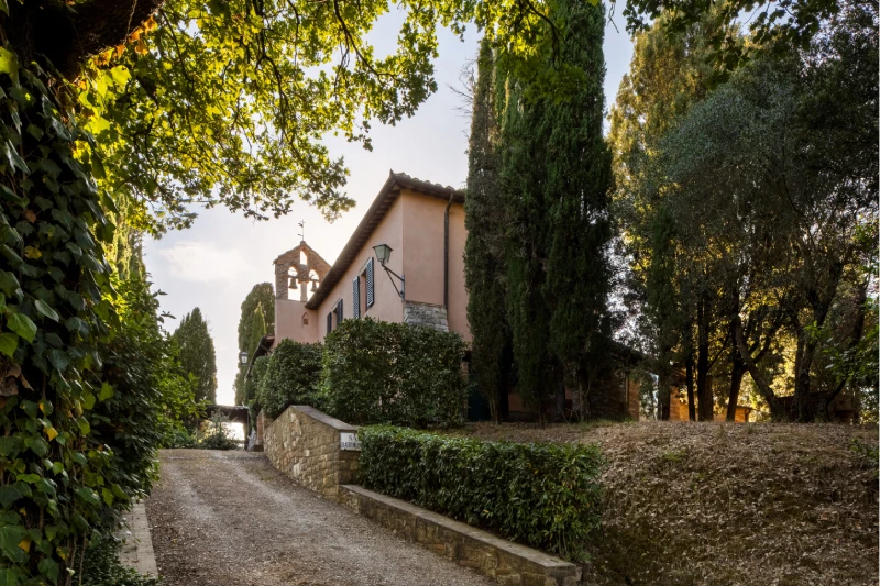 Villa entrance with cypress trees, gravel lane and small chapel in the greenery of the Crete Senesi near Asciano - Villa San Barolomeo, BZAR hotels in Tuscany