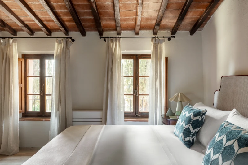 Bright bedroom with wooden windows, sheer curtains and white bed, Tuscan quiet in the heart of the Crete Senesi - Villa San Barolomeo, BZAR hotels in Tuscany