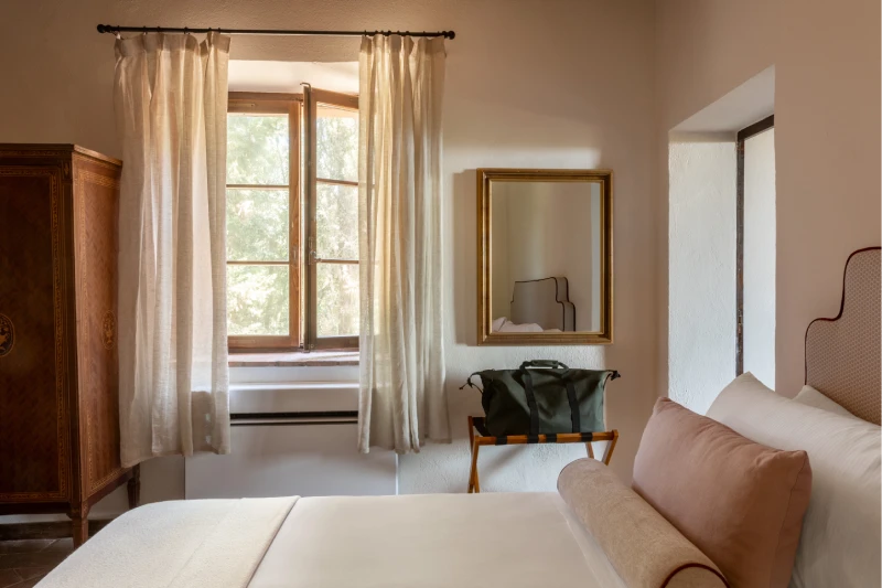 Refined bedroom with window opening onto greenery, decorated wardrobe and gilded mirror, authentic Tuscan relaxation - Villa San Barolomeo, BZAR hotels in Tuscany