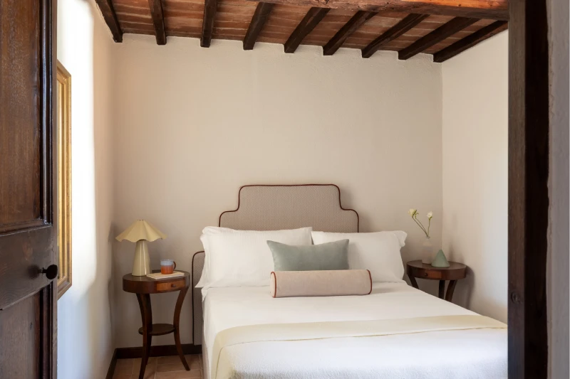 Double bedroom with white bed, neutral cushions and wardrobe details, Tuscan elegance for stays near Asciano - Villa San Barolomeo, BZAR hotels in Tuscany