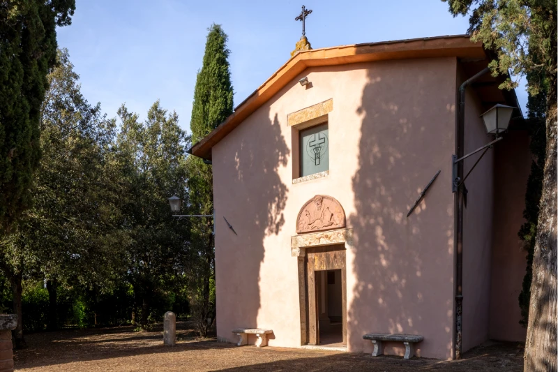 Small chapel with pink facade, stone doorway and mature trees, an authentic atmosphere in the Crete Senesi countryside - Villa San Barolomeo, BZAR hotels in Tuscany
